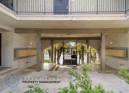 A building entrance with a sign that says Beach Front Property Management.