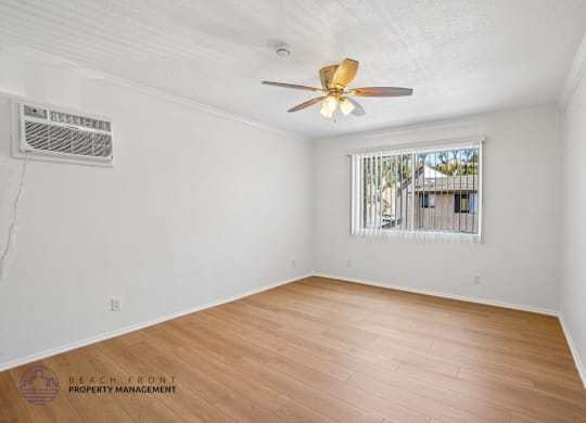 A room with a ceiling fan and wooden flooring.