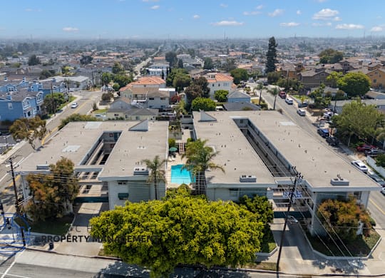 A bird's eye view of a city with buildings, roads, and a pool.