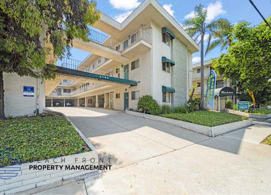 A multi-story building with a Peach Front Property Management sign in front.
