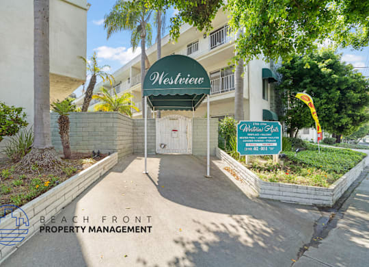 The entrance to a building named Westview with a sign for Beach Front Property Management.