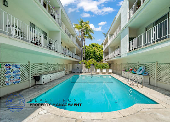 A pool in the middle of a courtyard surrounded by white buildings.