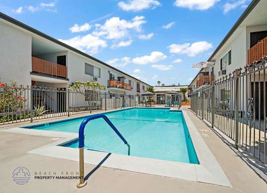 A swimming pool in a residential area with a blue metal handrail.