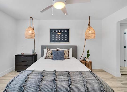 A bedroom with a large bed and a ceiling fan.