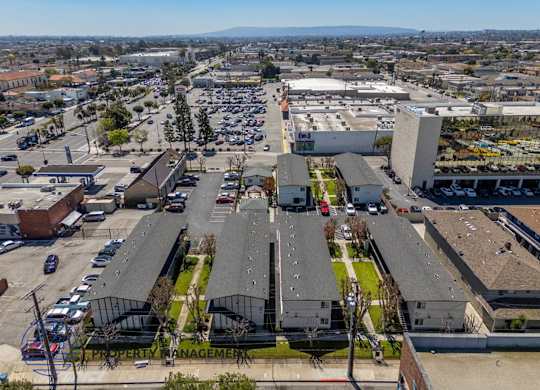 an aerial view of a parking lot and rooftops of buildings