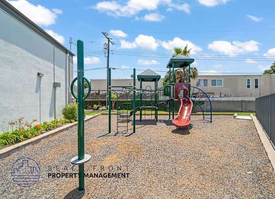 A playground with a slide and a green pole.