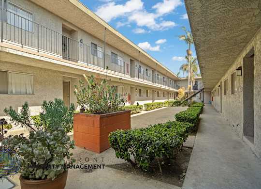 A courtyard with a brick planter and a sign that says Front Management.