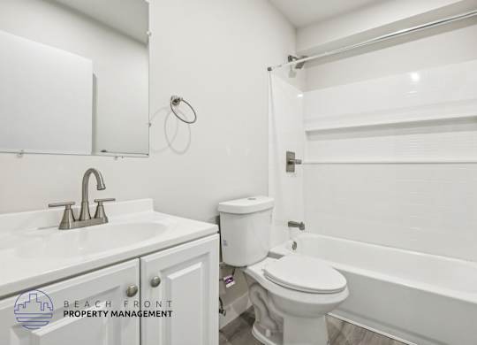 A white bathroom with a toilet, sink, and bathtub.