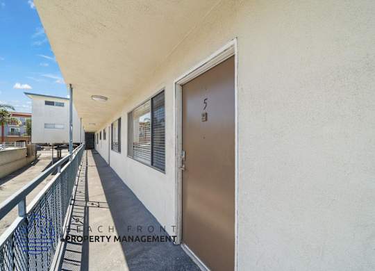 A balcony with a railing and a door with the number 5 on it.