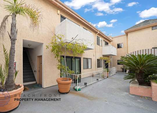 a building with a patio and a palm tree outside of it