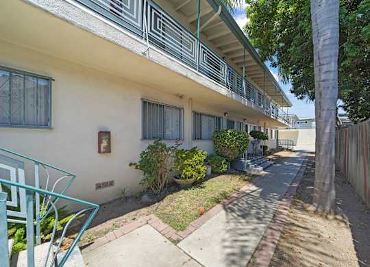 A white building with a balcony and a green chair.