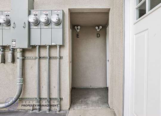 A utility area with pipes and meters outside a building.