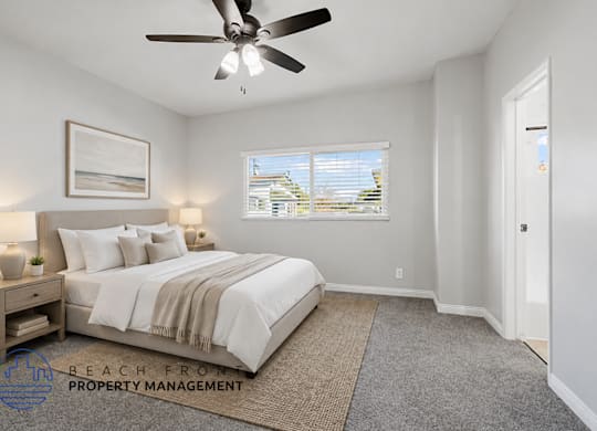 A bedroom with a large bed and a ceiling fan.