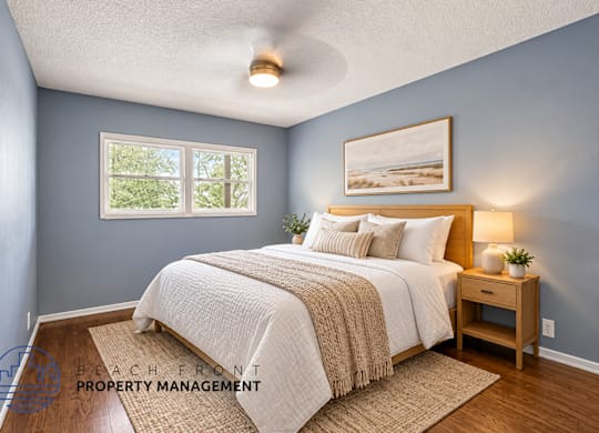 A bedroom with a bed, nightstand, and a painting on the wall.