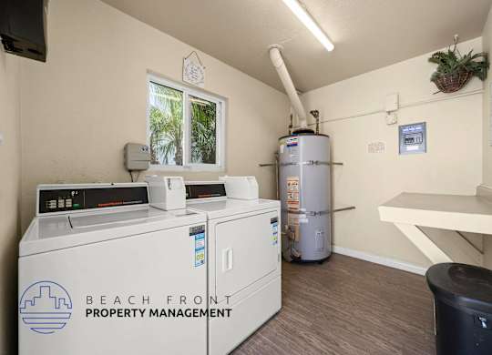 A room with a washing machine, dryer, and a water heater.