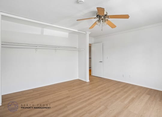 A room with a ceiling fan and a door.