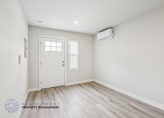 A room with a white door and a window with blinds, and a logo for Beach Front Property Management.