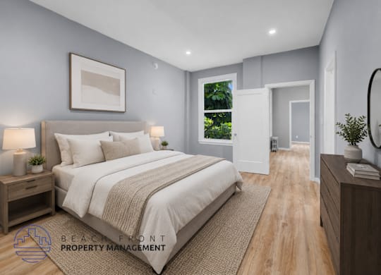 A well-lit bedroom with a large bed and a view of the outdoors through a window.