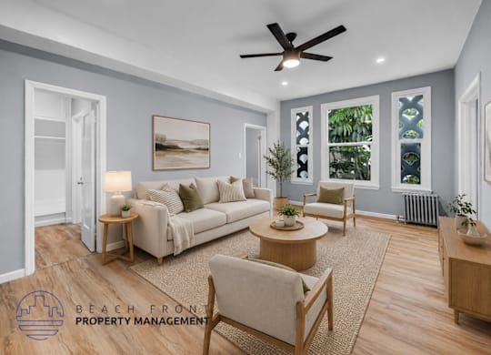 A living room with a couch, chairs, and a ceiling fan.