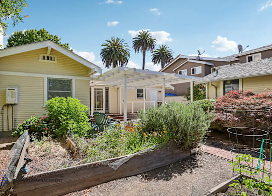 A sunny day in a residential area with houses and a garden.