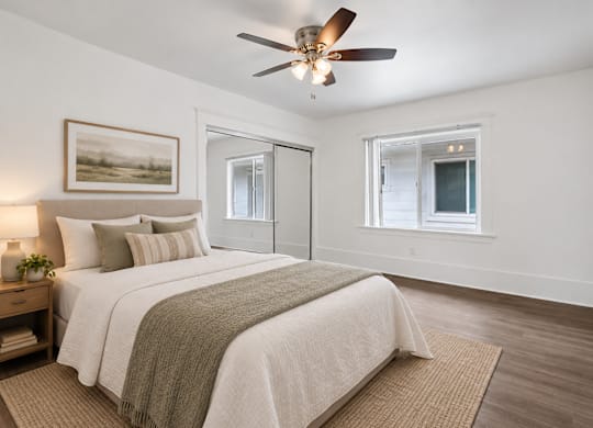 A bedroom with a large bed and a ceiling fan.