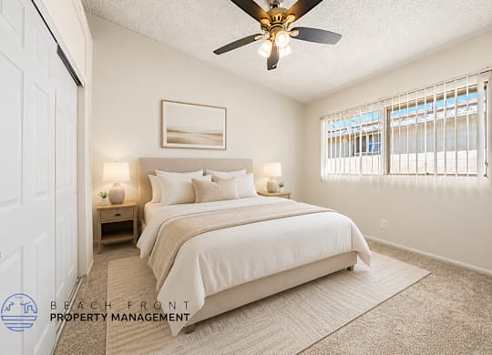 A bedroom with a large bed and a ceiling fan.