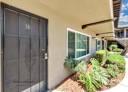 A black door with the number 38 on it is on a white wall.