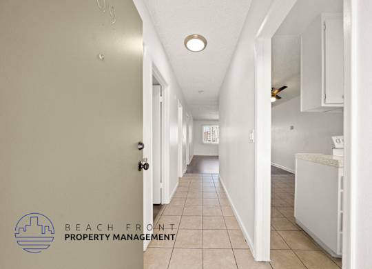 A long hallway with a logo for Beach Front Property Management in the bottom left corner.
