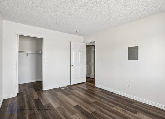 A room with a wooden floor and white walls.