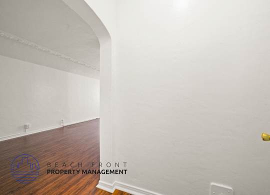 A room with a wooden floor and a white door.