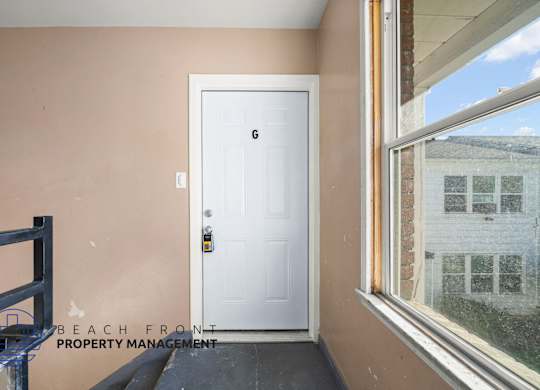 A white door with a black handle is in a room with a window.