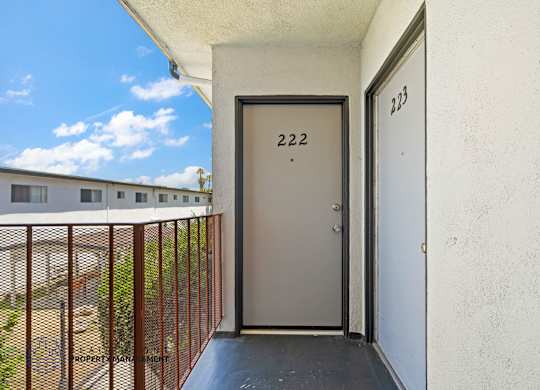 A balcony with a door numbered 222 and a window numbered 223.