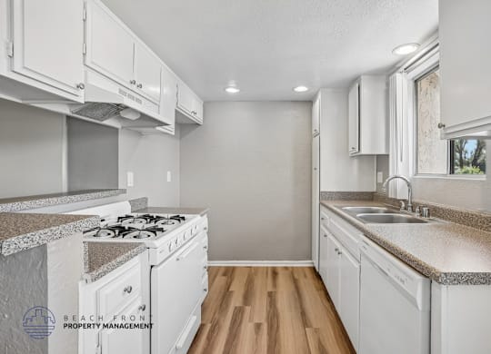A kitchen with white cabinets and a granite countertop.