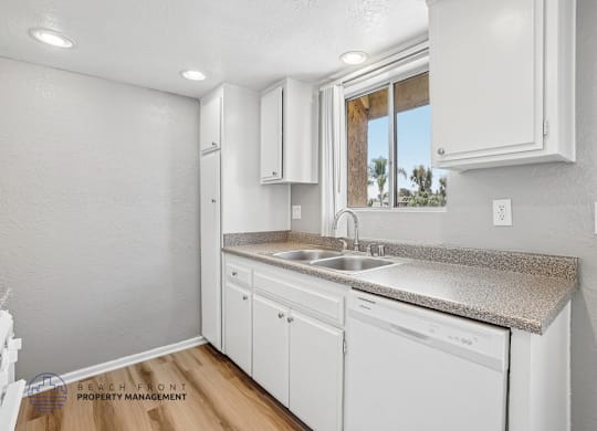 A kitchen with white cabinets and a granite countertop.