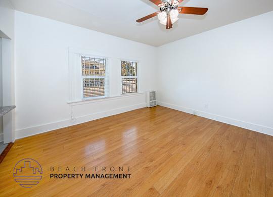 A room with wooden flooring and a ceiling fan.