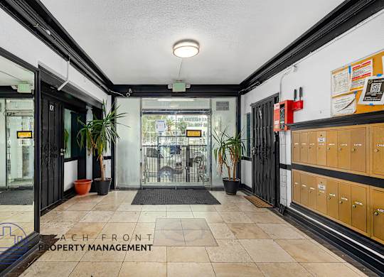 A hallway with a black railing and a glass door.
