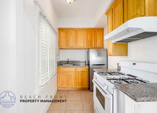 A kitchen with a stove top oven and a refrigerator.