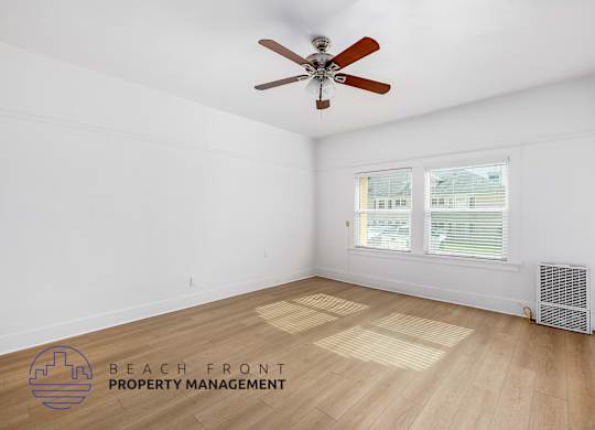 A room with a ceiling fan and a window with blinds.
