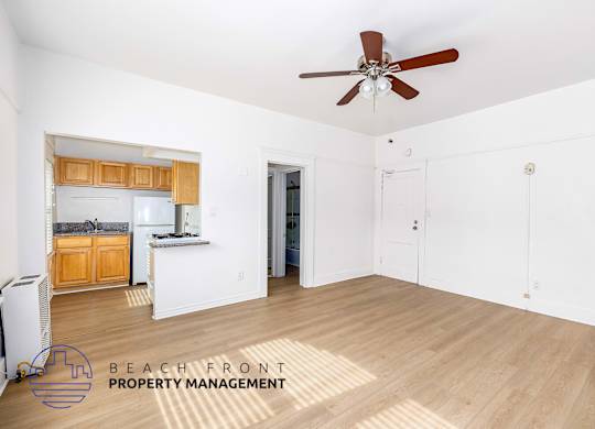 A spacious room with a ceiling fan and wooden flooring, managed by Beach Front Property Management.