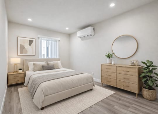 A bedroom with a large bed, a nightstand, and a dresser.