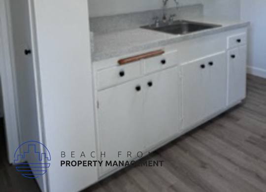 A kitchen with white cabinets and a sink.