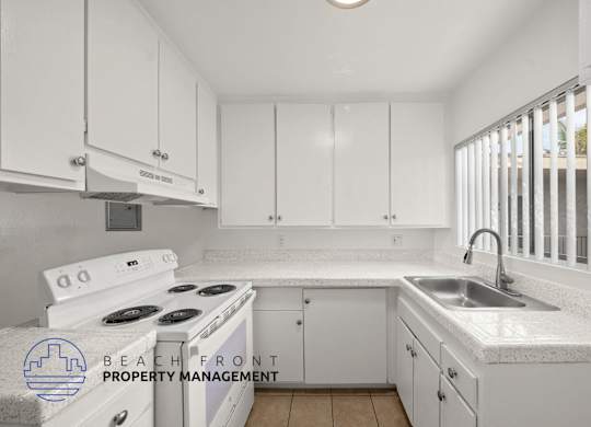 A kitchen with white cabinets and a stove top oven.