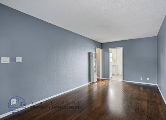 A spacious room with wooden floors and a white ceiling.