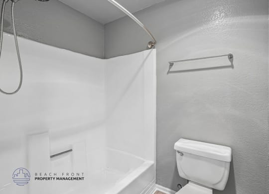 A white toilet in a bathroom with a white shower curtain.