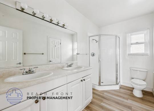 A bathroom with a white toilet, sink, and mirror.