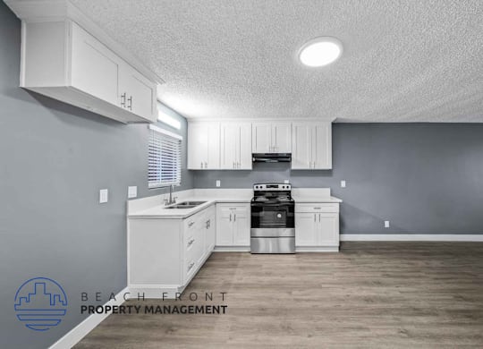 A kitchen with white cabinets and a stove top oven.