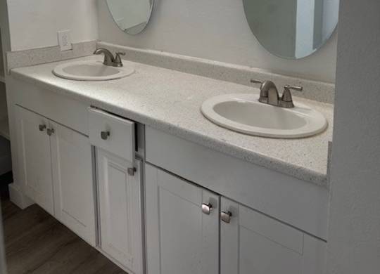 A bathroom with two sinks and two mirrors.