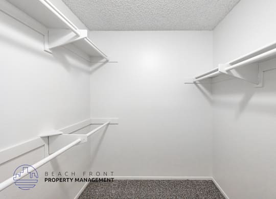 A white room with shelves and a logo for Beach Front Property Management.
