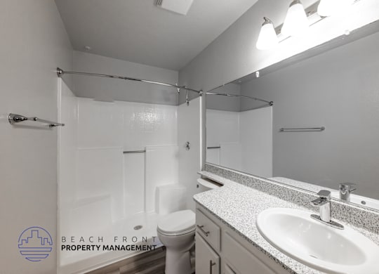 A bathroom with a toilet, sink, and mirror.