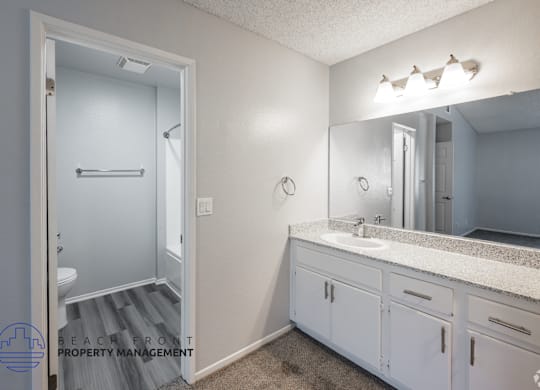 A bathroom with a white sink and a mirror above it.